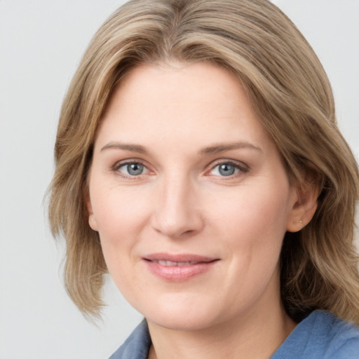 Joyful white young-adult female with medium  brown hair and blue eyes