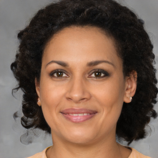 Joyful black adult female with medium  brown hair and brown eyes