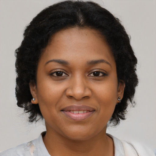 Joyful black adult female with long  brown hair and brown eyes