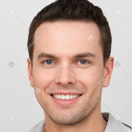 Joyful white young-adult male with short  brown hair and grey eyes