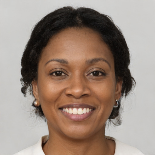 Joyful black adult female with medium  brown hair and brown eyes