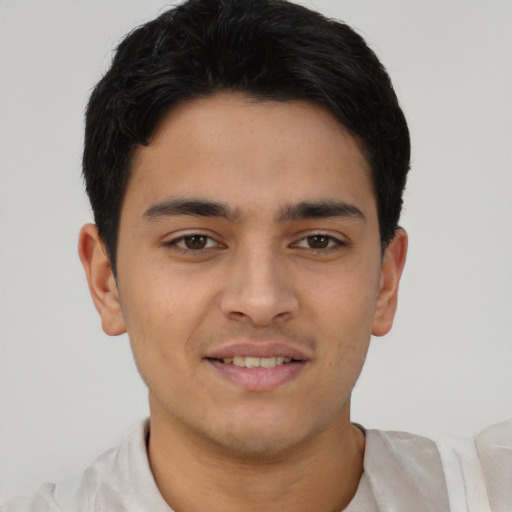 Joyful latino young-adult male with short  brown hair and brown eyes