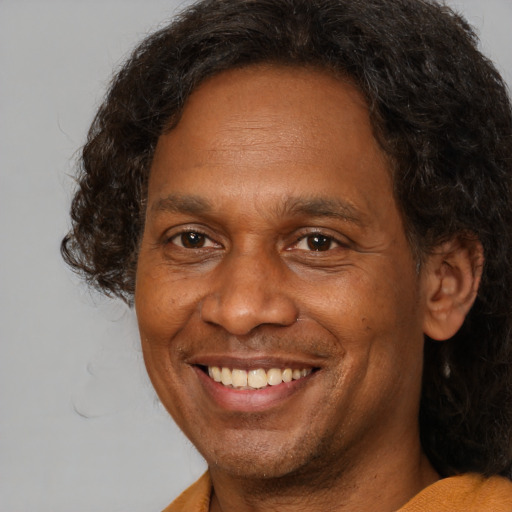 Joyful black adult male with short  brown hair and brown eyes