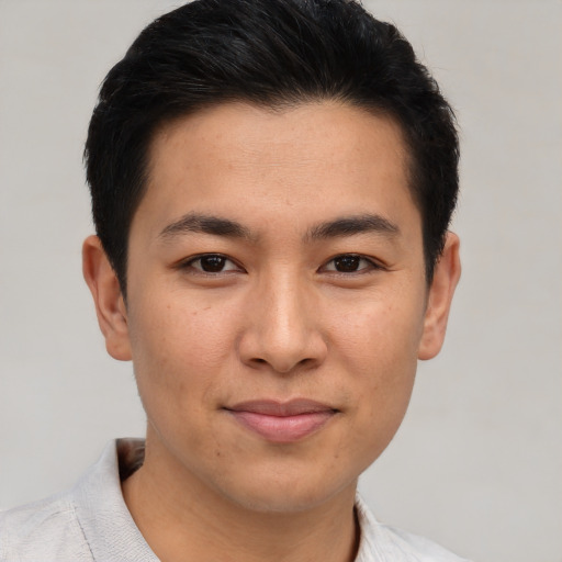 Joyful asian young-adult male with short  brown hair and brown eyes