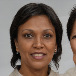 Joyful black adult female with medium  brown hair and brown eyes