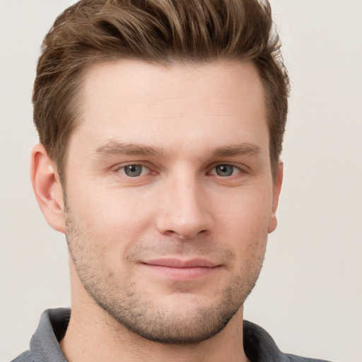 Joyful white young-adult male with short  brown hair and grey eyes