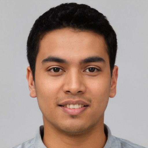 Joyful latino young-adult male with short  black hair and brown eyes