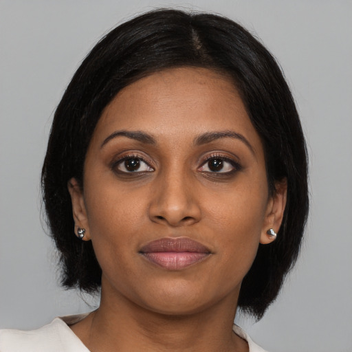 Joyful black young-adult female with medium  brown hair and brown eyes