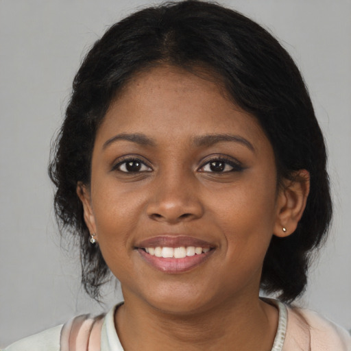 Joyful black young-adult female with medium  brown hair and brown eyes