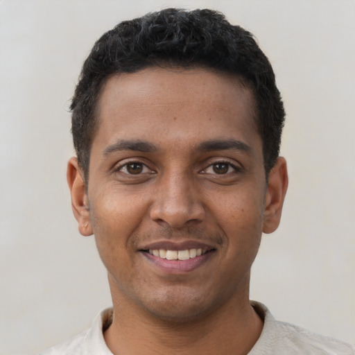 Joyful black young-adult male with short  black hair and brown eyes
