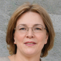 Joyful white adult female with medium  brown hair and blue eyes