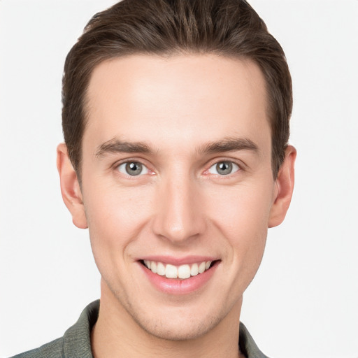 Joyful white young-adult male with short  brown hair and grey eyes