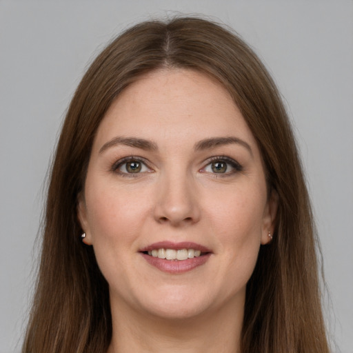 Joyful white young-adult female with long  brown hair and grey eyes