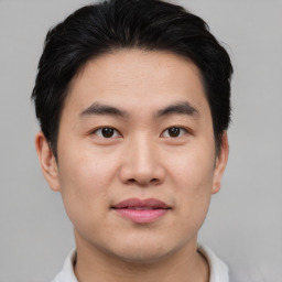 Joyful asian young-adult male with short  brown hair and brown eyes