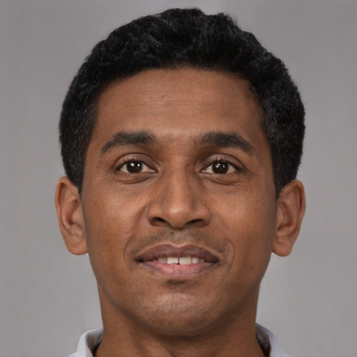 Joyful black young-adult male with short  brown hair and brown eyes