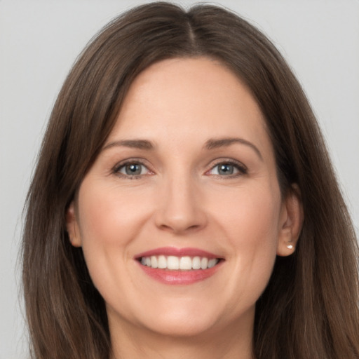 Joyful white young-adult female with long  brown hair and grey eyes