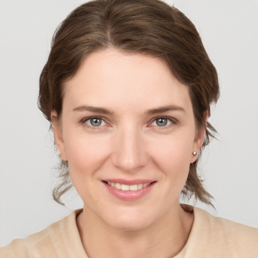 Joyful white young-adult female with medium  brown hair and grey eyes