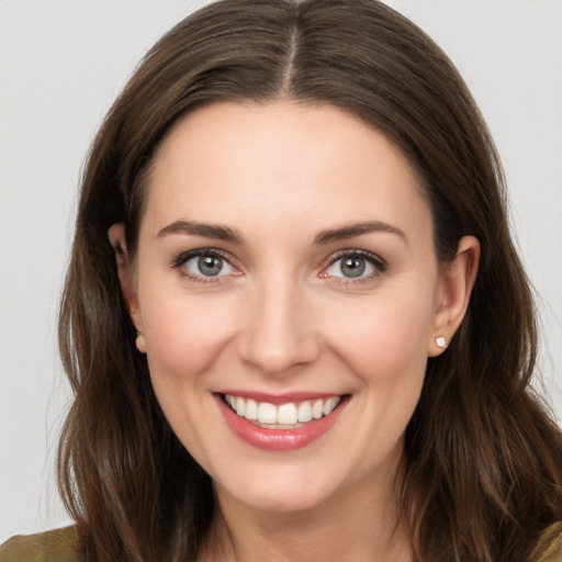 Joyful white young-adult female with long  brown hair and brown eyes