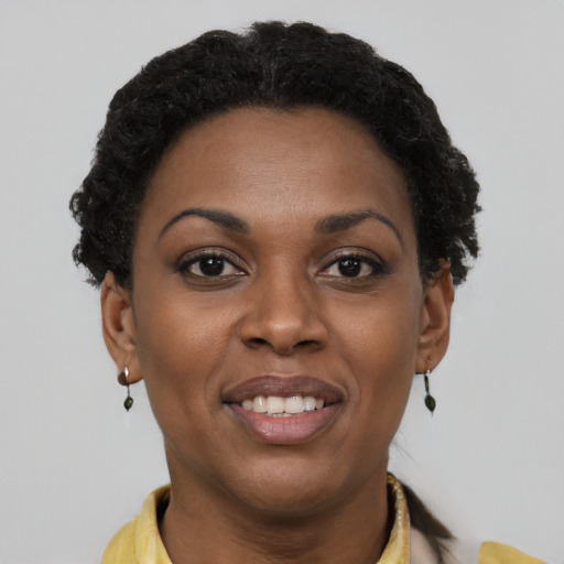 Joyful black young-adult female with short  brown hair and brown eyes