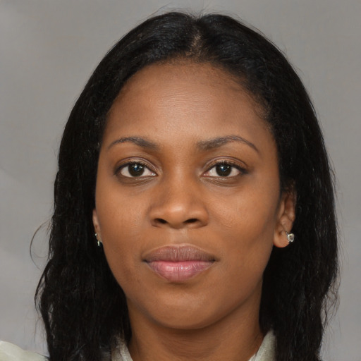 Joyful black young-adult female with long  brown hair and brown eyes