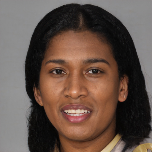 Joyful black young-adult female with long  black hair and brown eyes