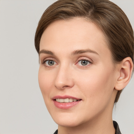 Joyful white young-adult female with medium  brown hair and grey eyes