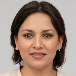 Joyful latino young-adult female with medium  brown hair and brown eyes