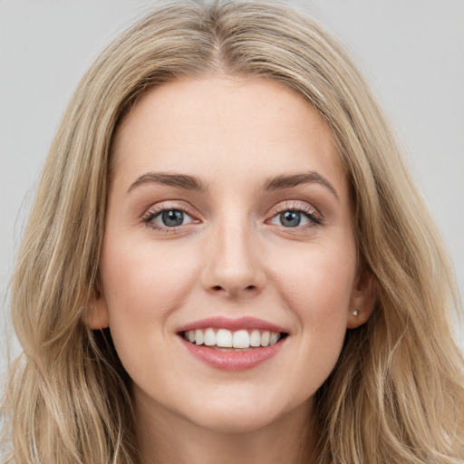 Joyful white young-adult female with long  brown hair and blue eyes