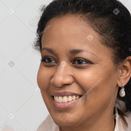 Joyful black young-adult female with short  brown hair and brown eyes