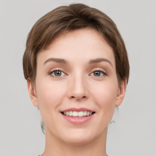 Joyful white young-adult female with short  brown hair and grey eyes