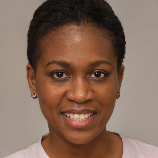 Joyful black young-adult female with short  black hair and brown eyes