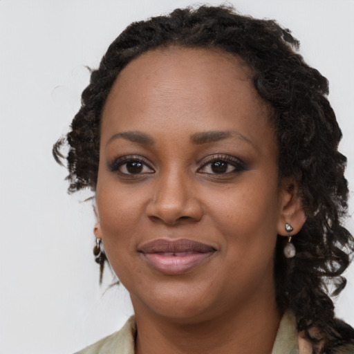 Joyful black young-adult female with long  brown hair and brown eyes