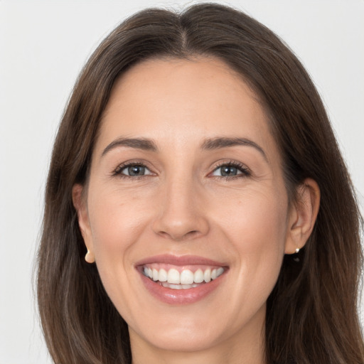 Joyful white adult female with long  brown hair and brown eyes