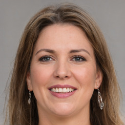 Joyful white young-adult female with long  brown hair and grey eyes