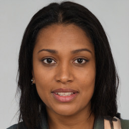 Joyful black young-adult female with long  brown hair and brown eyes