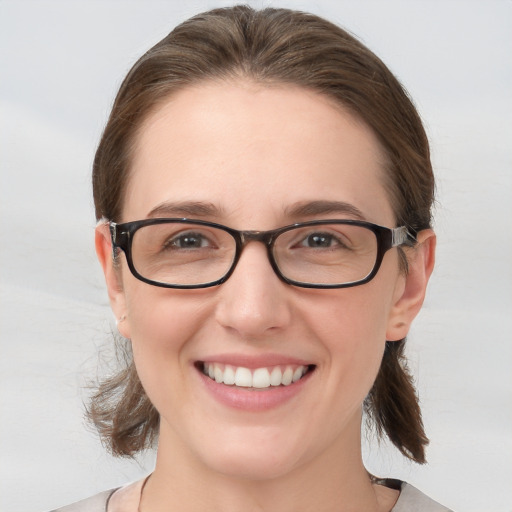 Joyful white young-adult female with medium  brown hair and grey eyes