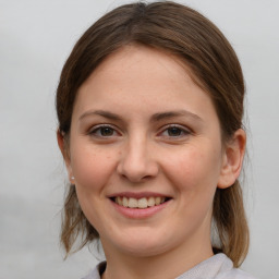 Joyful white young-adult female with medium  brown hair and grey eyes