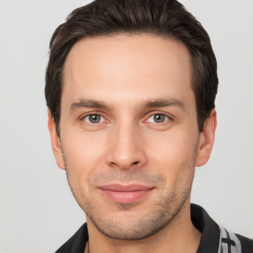 Joyful white young-adult male with short  brown hair and brown eyes