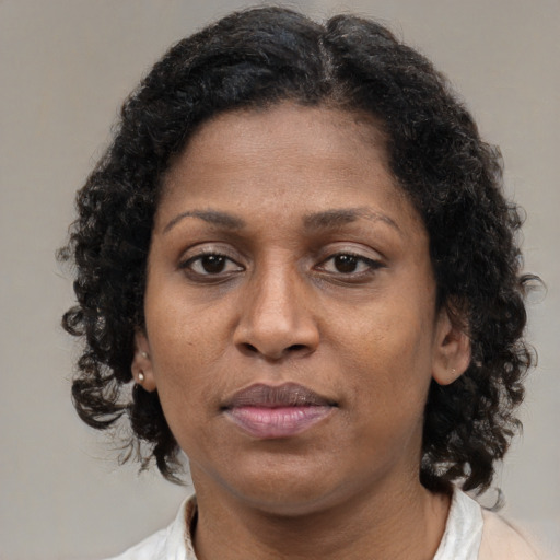 Joyful black adult female with medium  brown hair and brown eyes