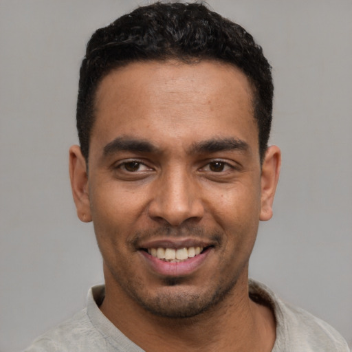 Joyful latino young-adult male with short  black hair and brown eyes