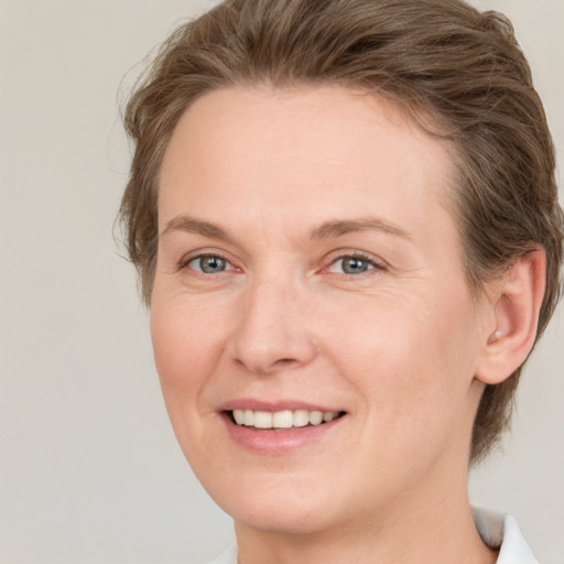 Joyful white young-adult female with medium  brown hair and green eyes