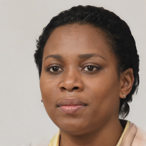 Joyful black young-adult female with short  black hair and brown eyes