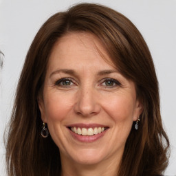 Joyful white adult female with long  brown hair and grey eyes