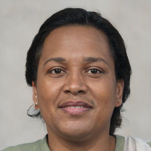 Joyful black adult female with short  brown hair and brown eyes