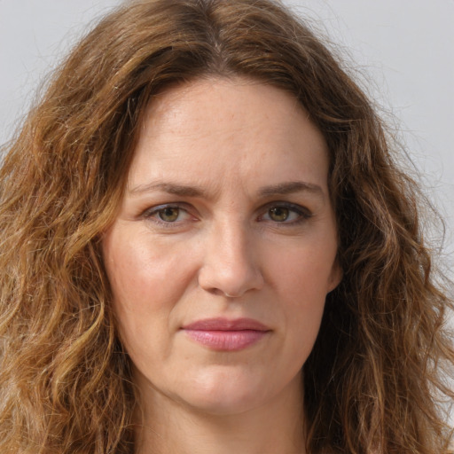 Joyful white adult female with long  brown hair and green eyes