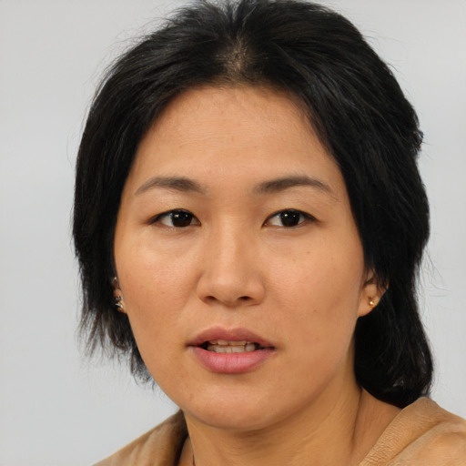 Joyful asian adult female with medium  brown hair and brown eyes
