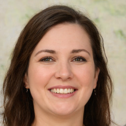 Joyful white young-adult female with long  brown hair and green eyes