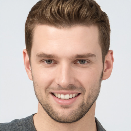 Joyful white young-adult male with short  brown hair and grey eyes