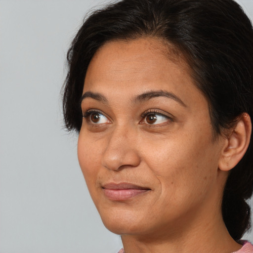 Joyful black adult female with medium  brown hair and brown eyes