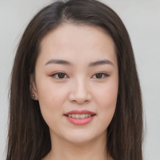 Joyful asian young-adult female with long  brown hair and brown eyes